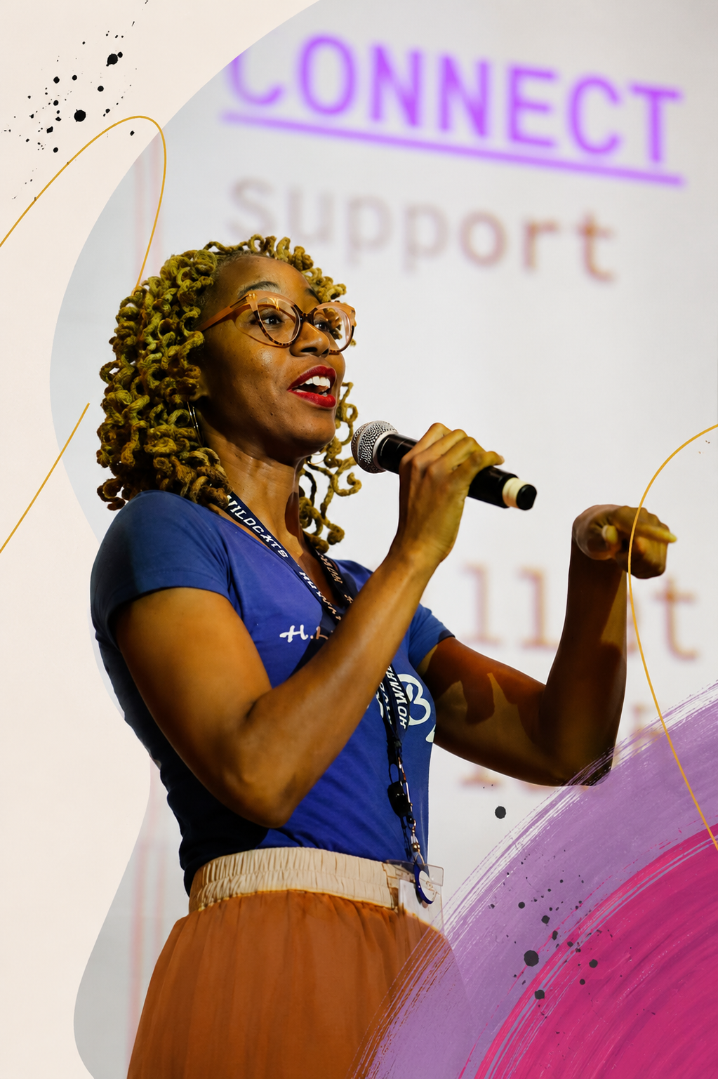 Aisha speaking into a microphone on stage at a school assembly